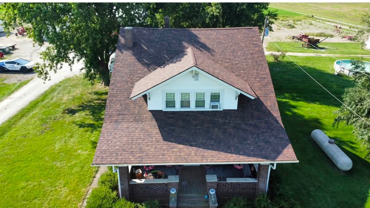Aerial view of a historic farmhouse with a newly installed Owens Corning shingle roof by Affordable Roofing after a complete tear-off