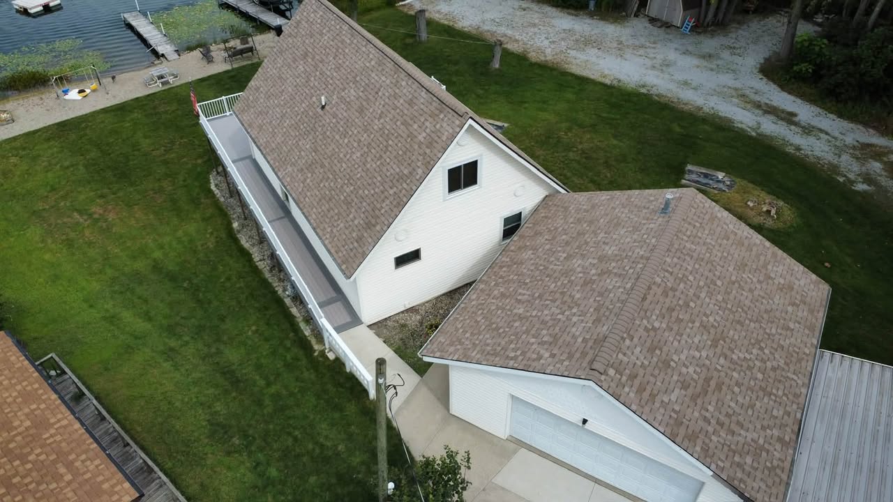 Aerial view of a lake house in Columbia City, IN with a newly installed Owens Corning Duration Sandcastle shingle roof by Affordable Roofing